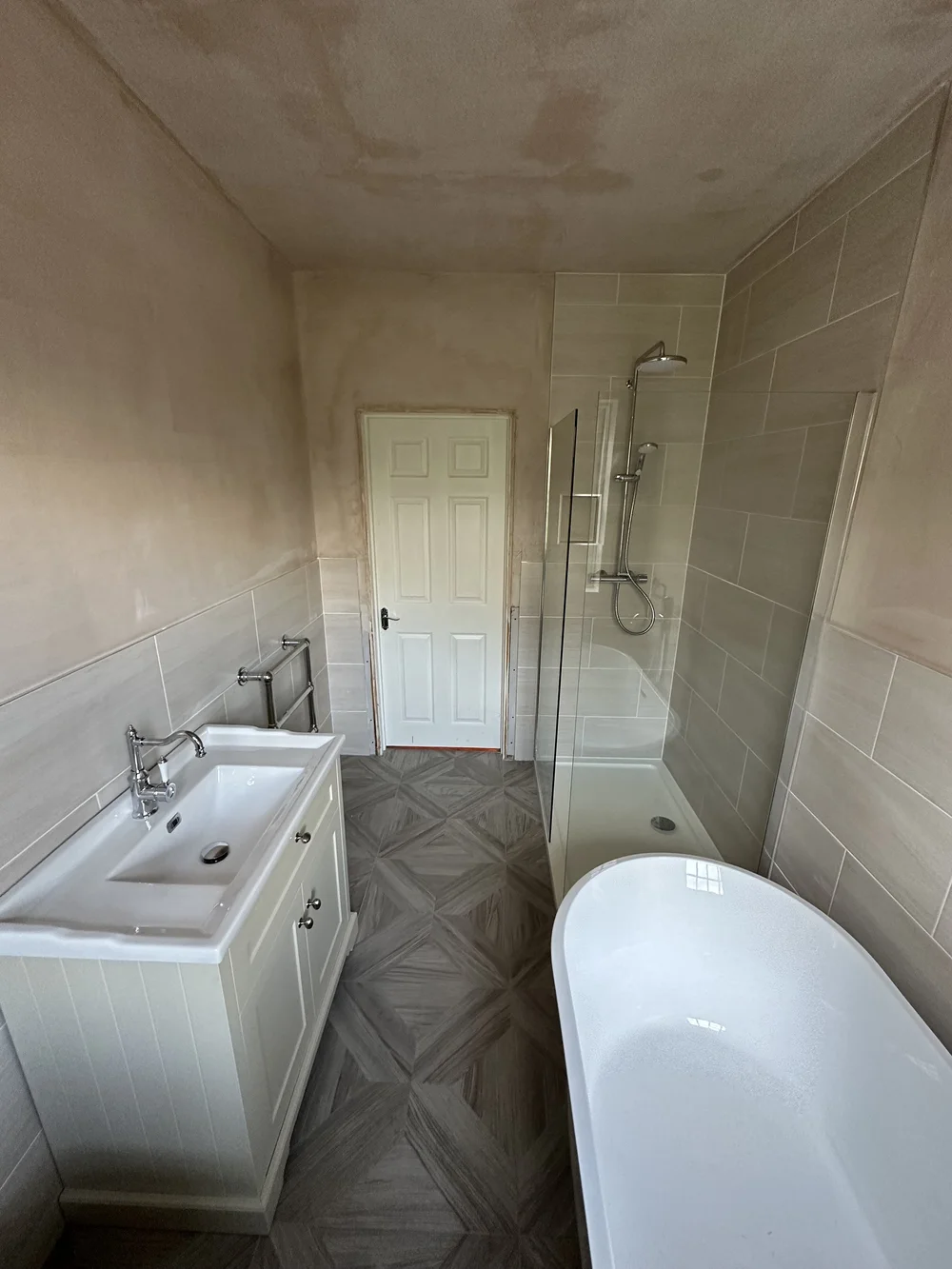 Family bathroom mid-renovation with fresh plaster, shaker vanity, walk-in shower and freestanding bath — bathroom renovation Godalming