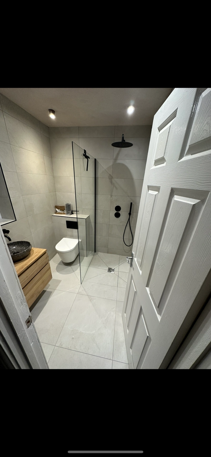 Modern wet room with oak vanity, stone vessel and matte black shower fittings — bathroom installation Godalming