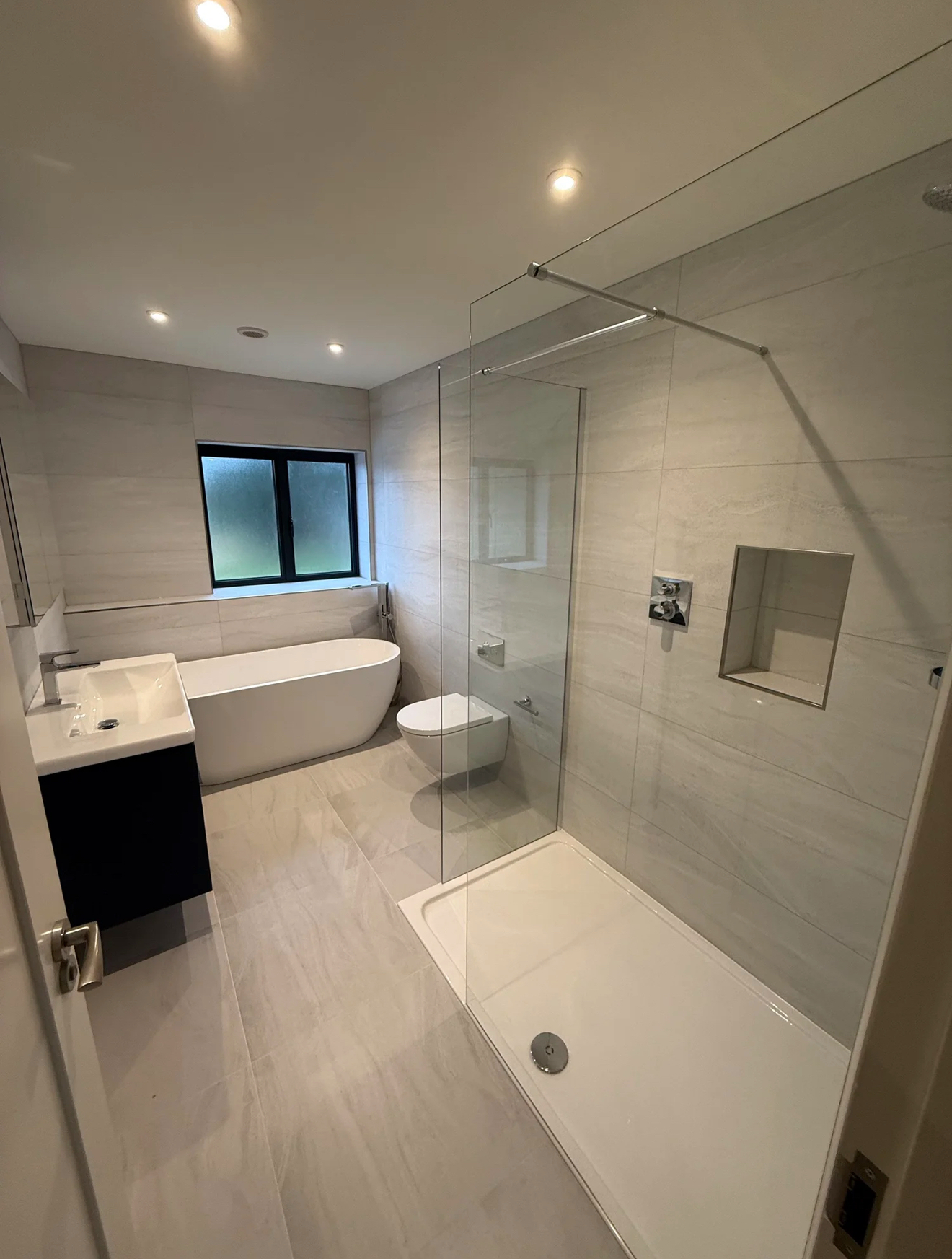 Family bathroom with freestanding bath, walk-in shower and dark vanity — recent project Godalming