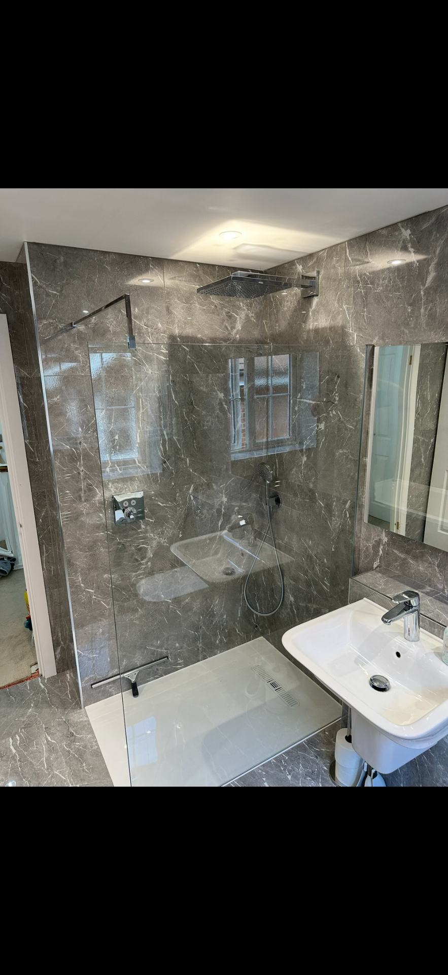 Grey marble walk-in shower with rainfall head and frameless glass — wet room Godalming