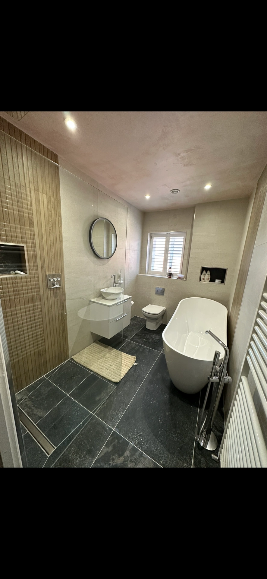 Master bathroom with freestanding tub, slate floor and oak-panelled walk-in shower — bathroom installation Godalming