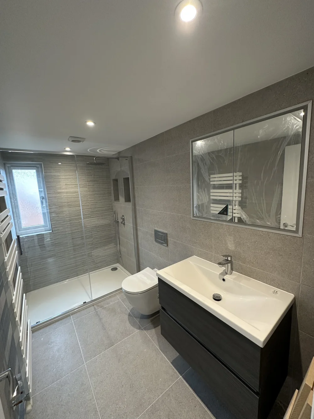 Contemporary shower room with graphite vanity, walk-in shower and mirrored cabinet — bathroom renovation Godalming