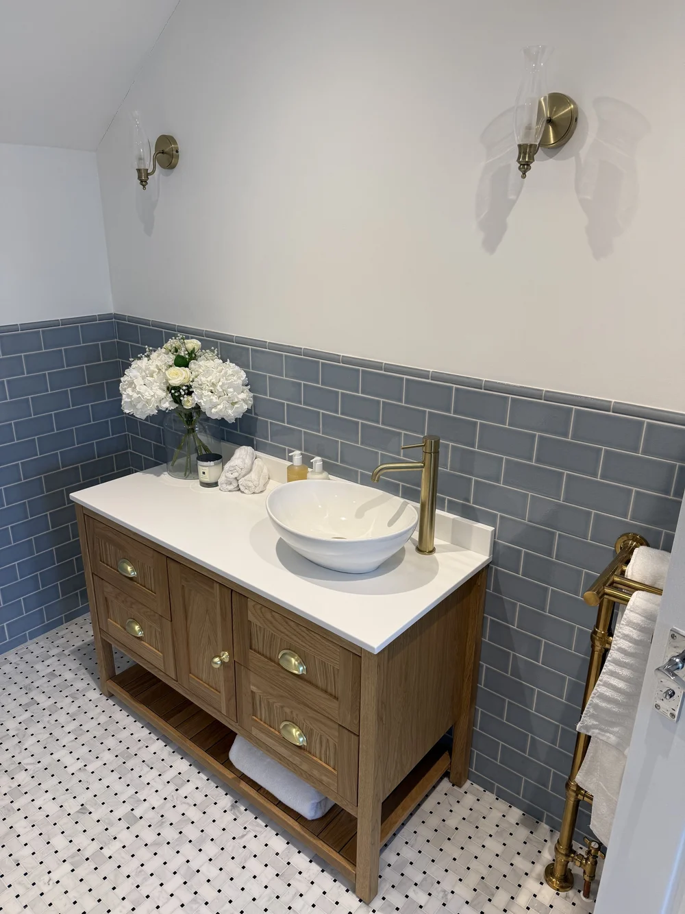 Oak vanity with vessel basin, brass tap and blue metro tiles — bathroom design Godalming