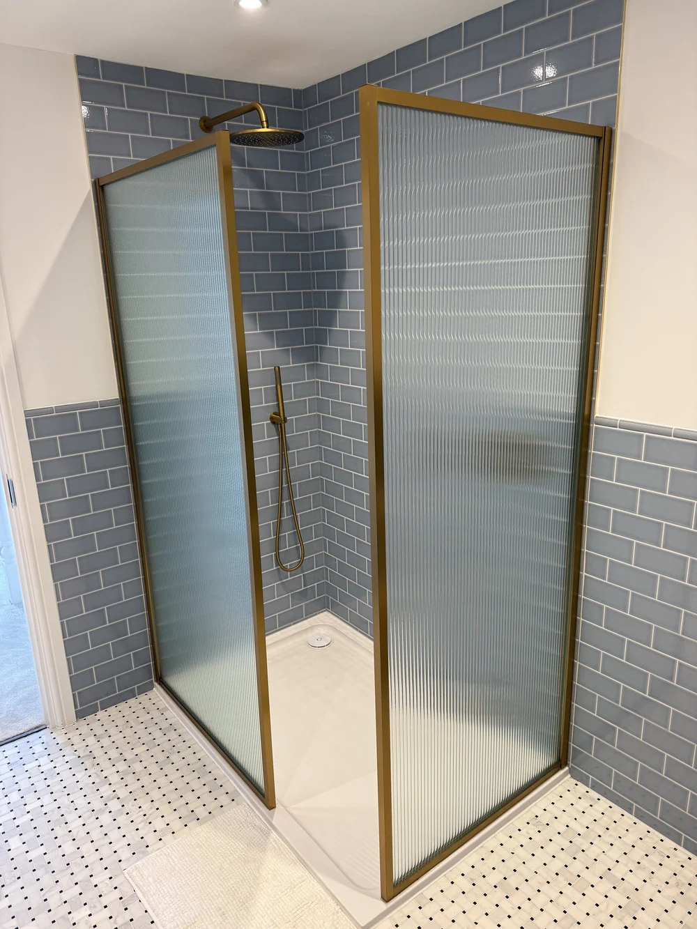 Blue metro tile walk-in shower with brushed brass fluted screens — Godalming bathroom fitters