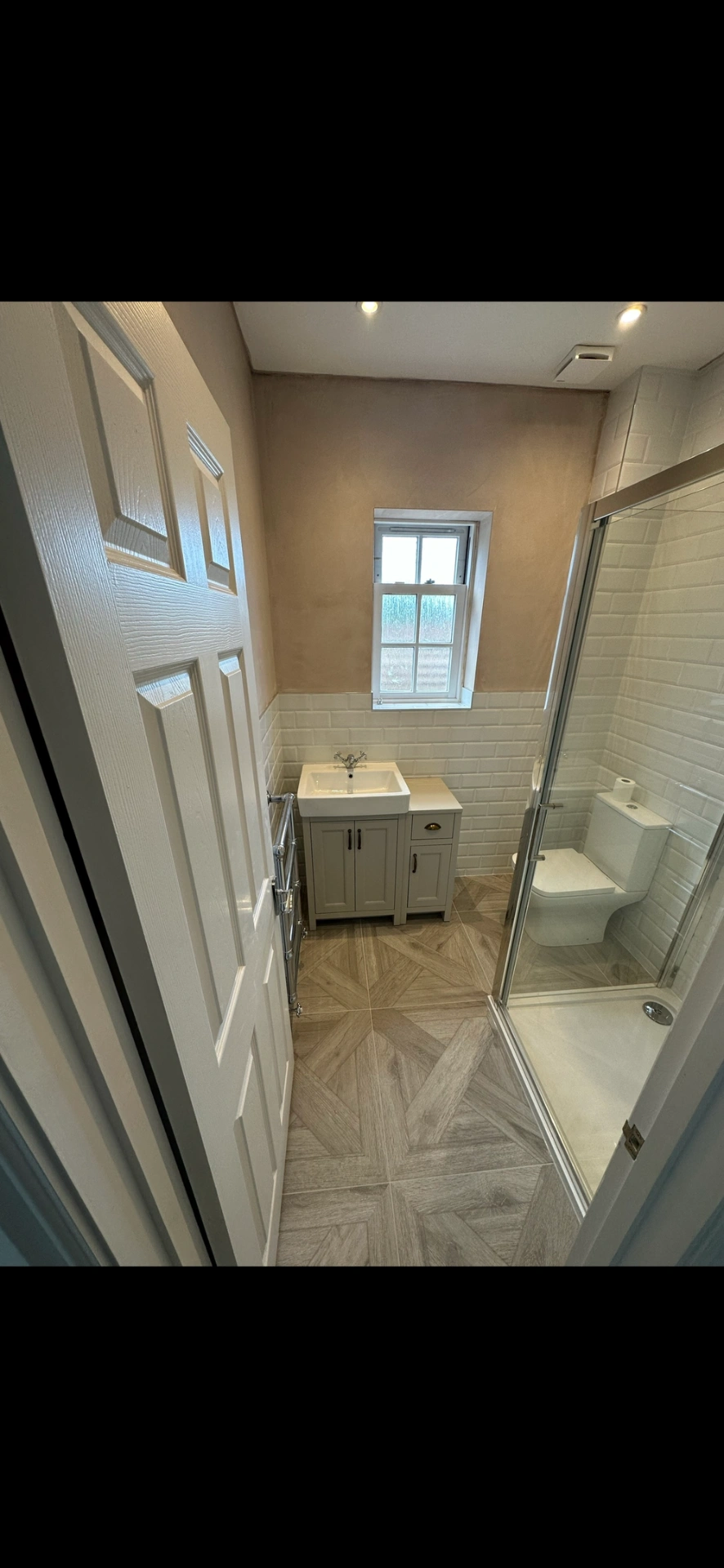 Compact shower room with shaker vanity, beveled metro tiles and chevron parquet floor — bathroom installation Godalming