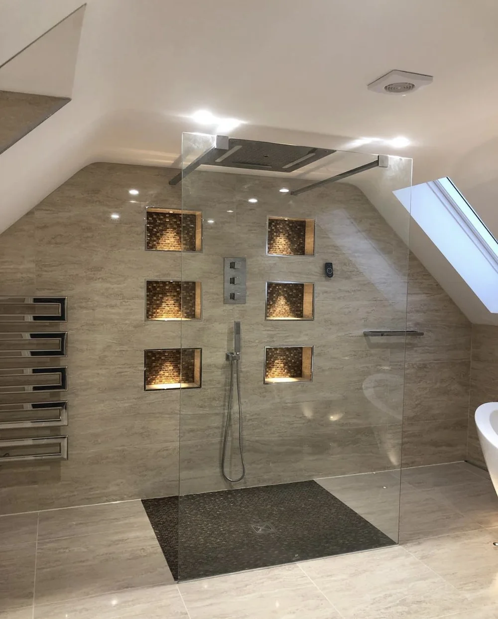 Luxury loft wet room with travertine walls, mosaic niches and frameless glass screen — Godalming bathroom fitters